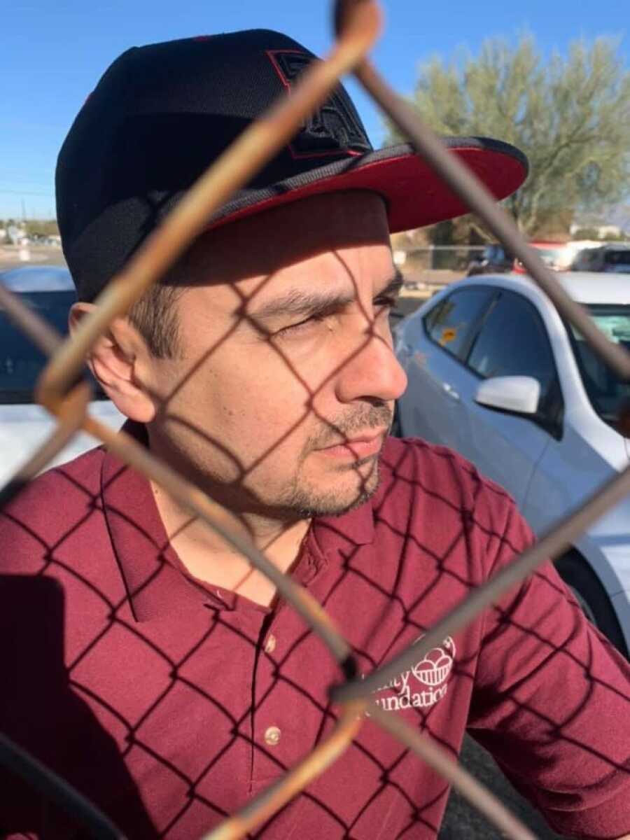 man starin through a fence representing prison