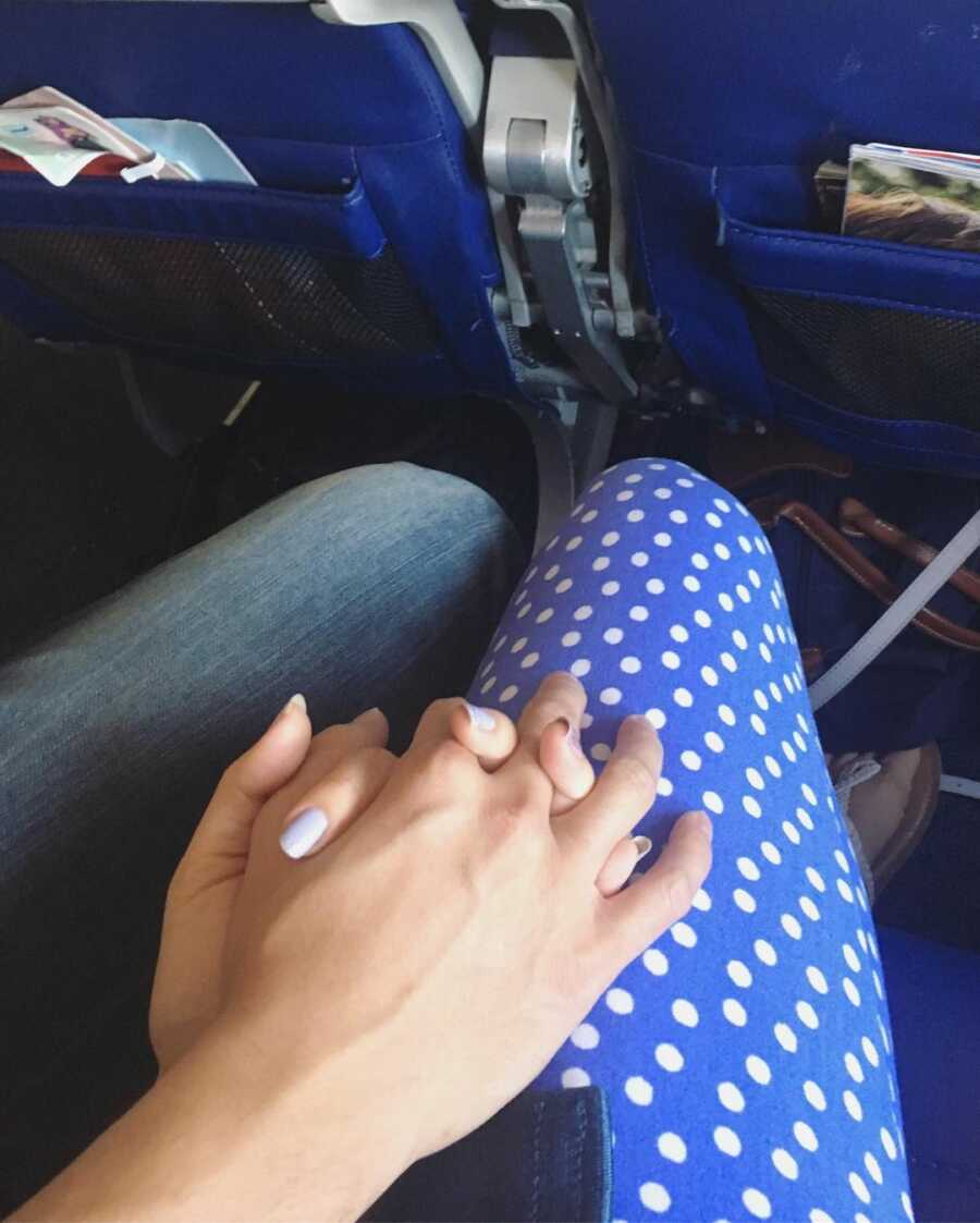 husband and wife holding hands as the plane takes off