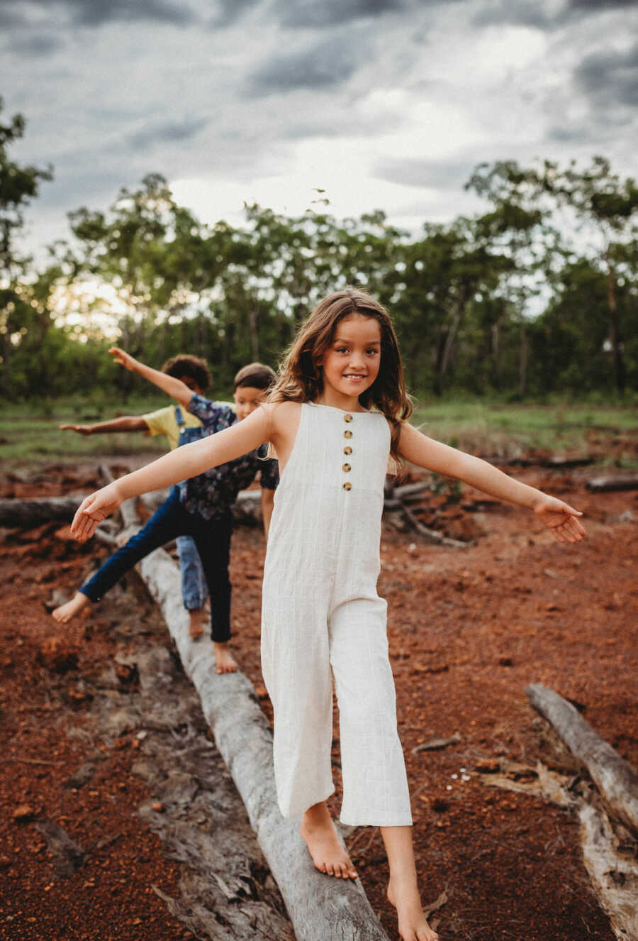 kids walking on a log trying to balance