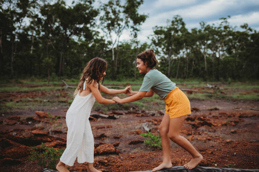 two sisters who are playing in the mud