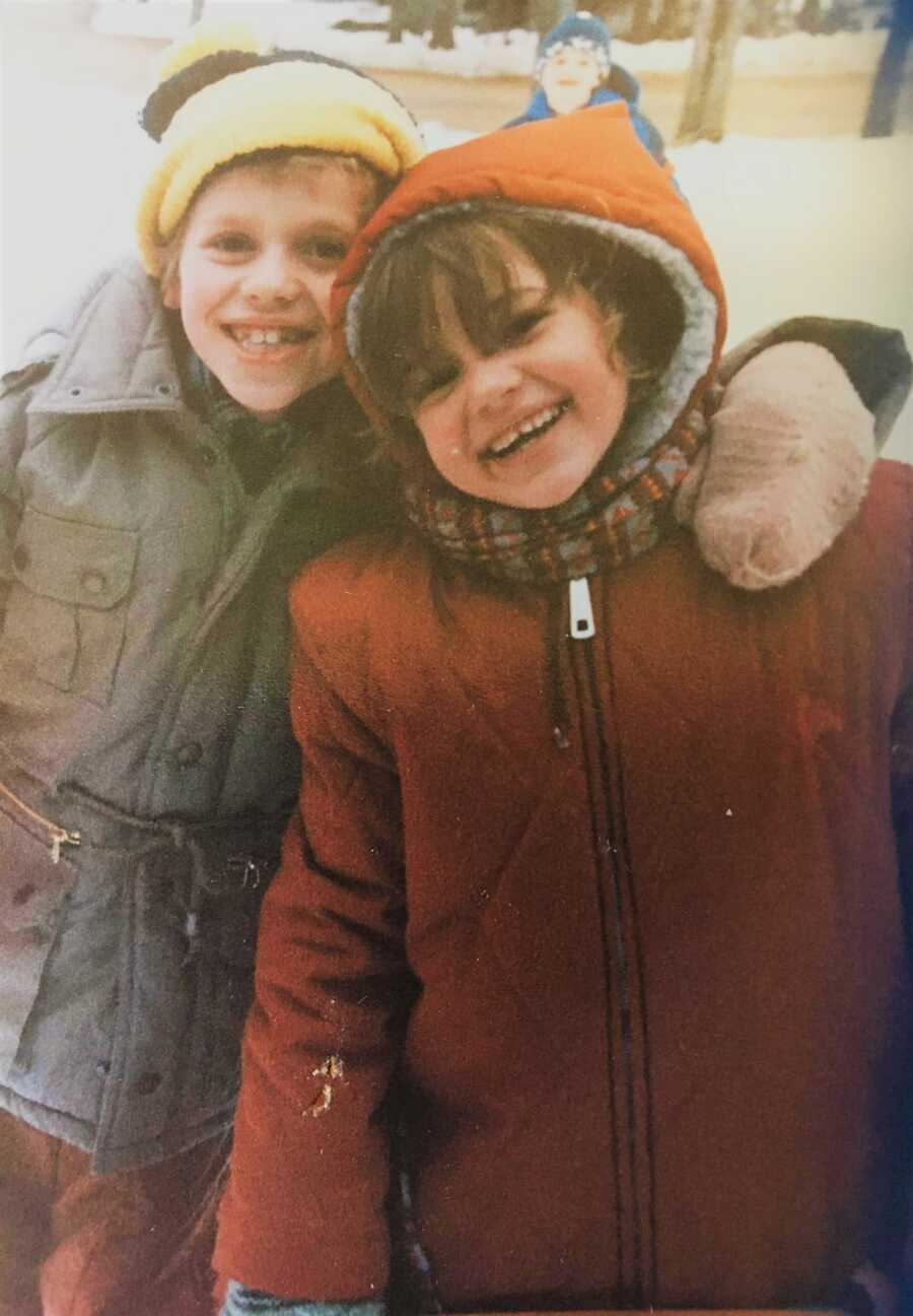brother and sister in the snow smiling