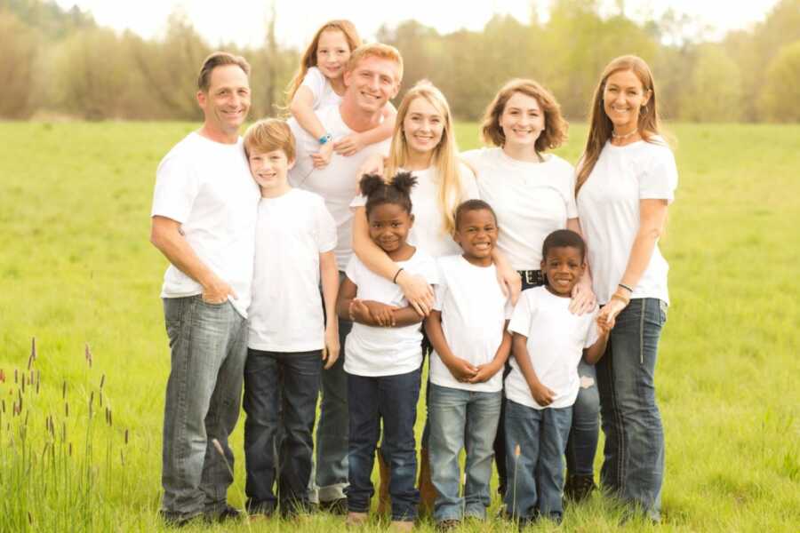 Parents with five biological children and 3 adoptive children take a family photo in matching outfits