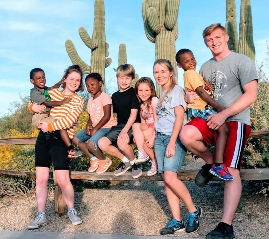 Mom takes a photo of her eight children together during vacation with cactuses behind them