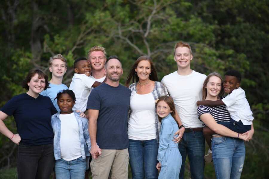 Family of ten take a group photo, all wearing blue and white