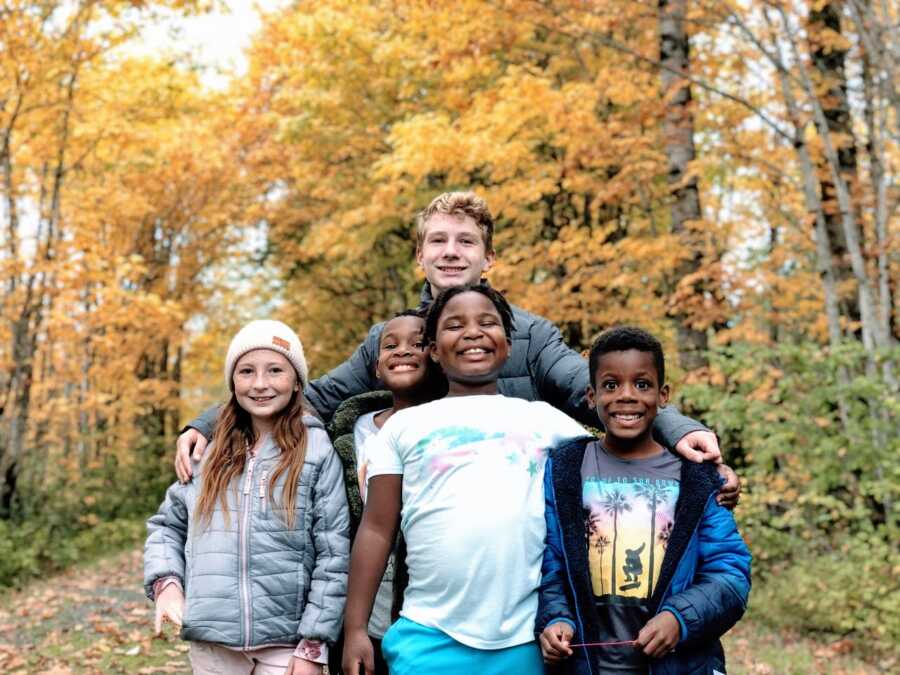 Mom takes a photo of five of her children all smiling big while out on a walk in the beautiful scenery of Oregon