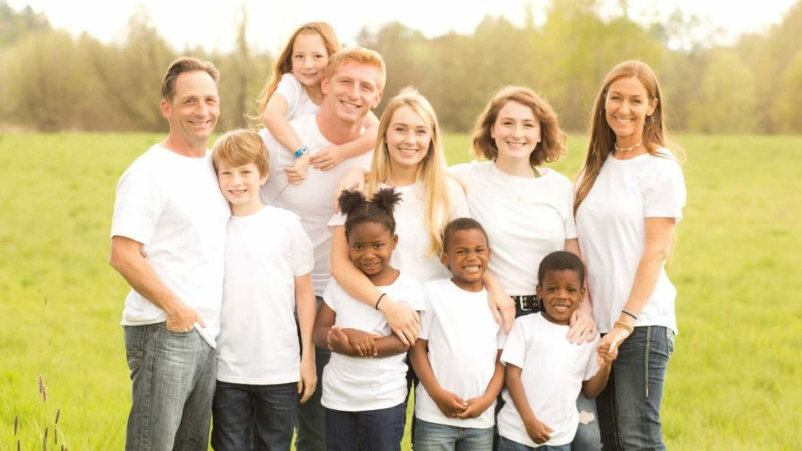Family of 10 smile big for a group photo in matching outfits
