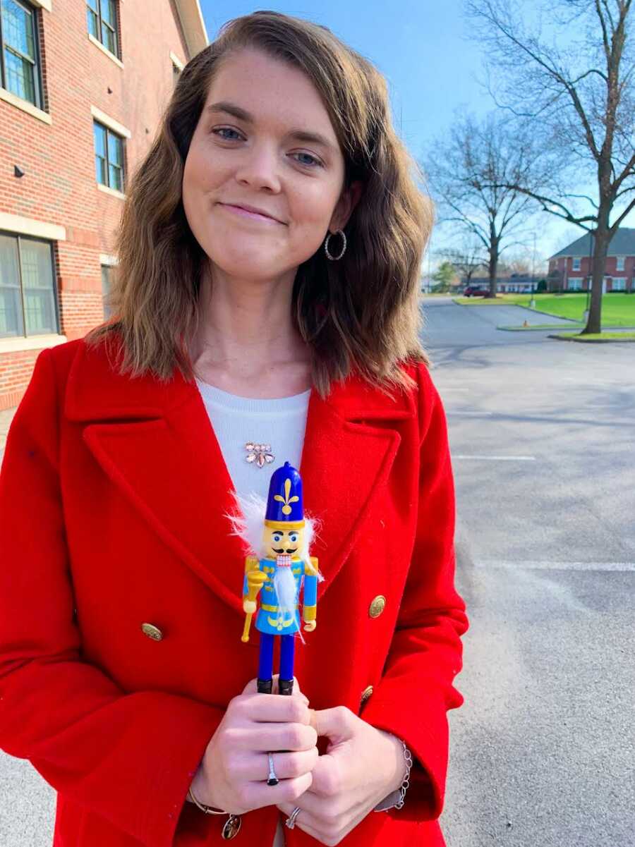 Young woman potentially battling rare Nutcracker Syndrome takes a photo with a nutcracker