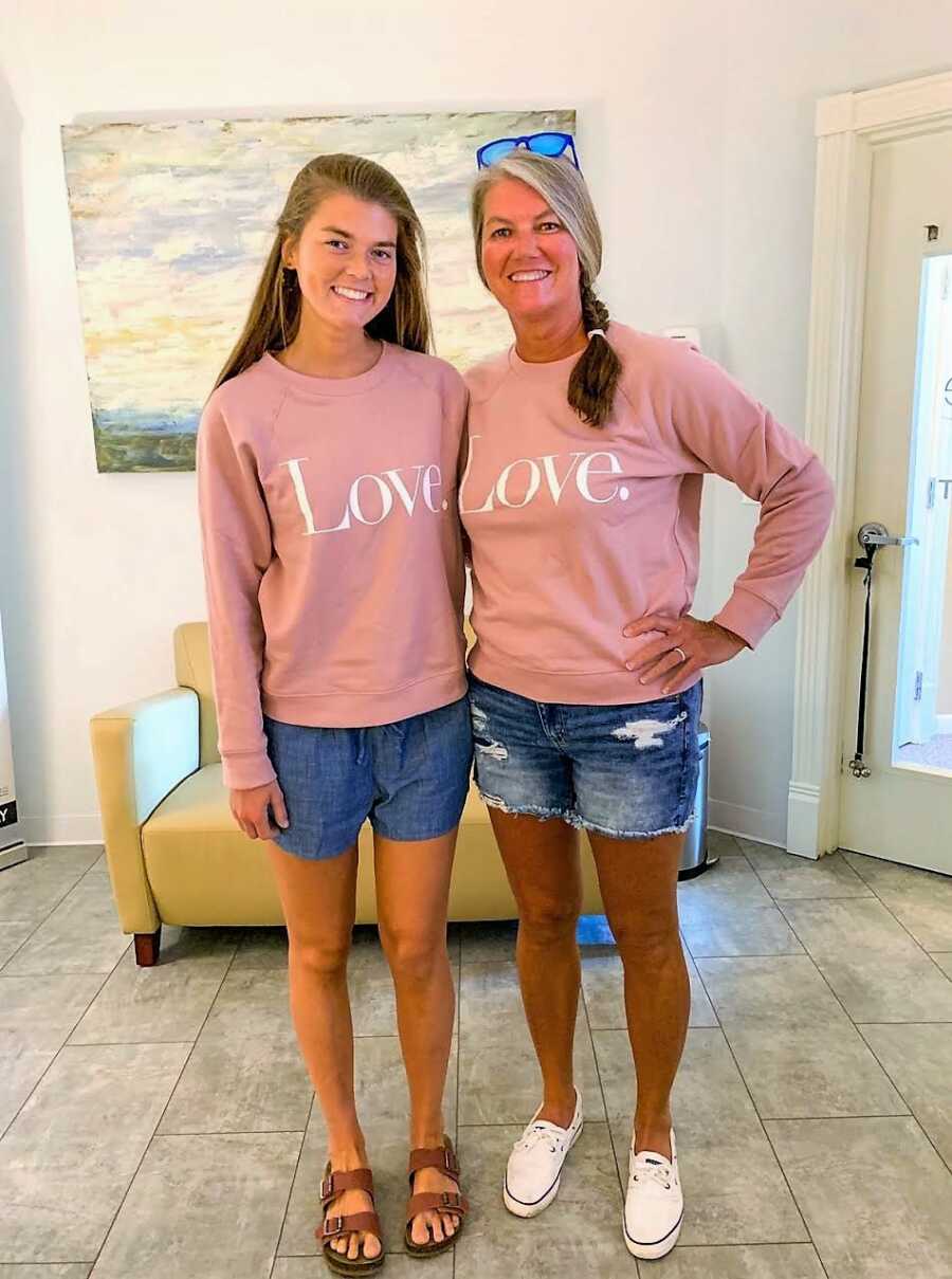 Young woman and mom take a photo in matching 'Love' sweatshirts