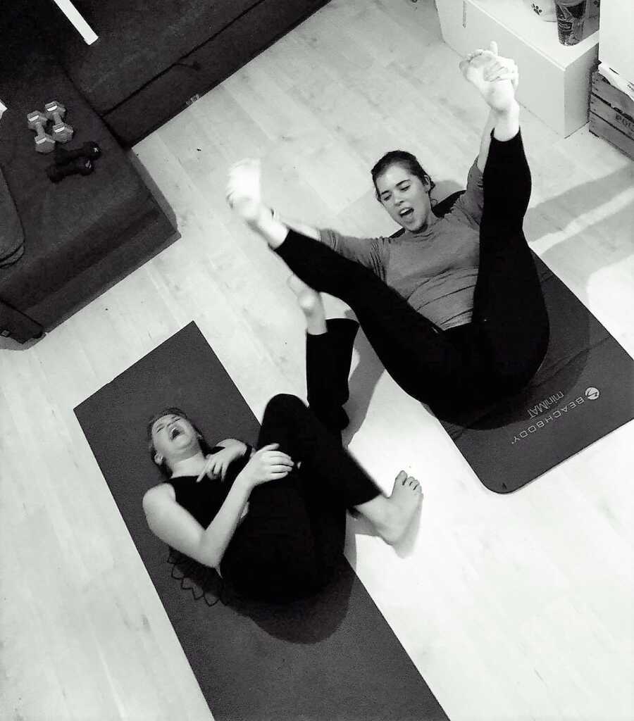 woman exercising with a friend on a yoga mat