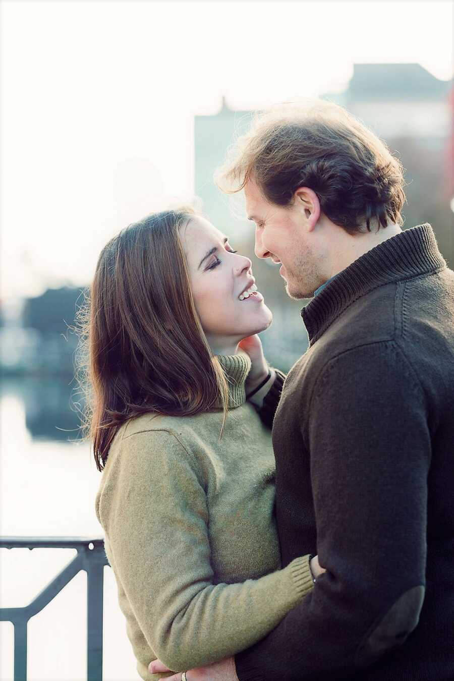 American girl and Dutch man stare at each other on a bridge 