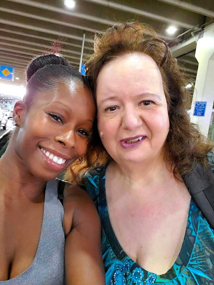 Adoptive mother and daughter smile at camera for a selfie.