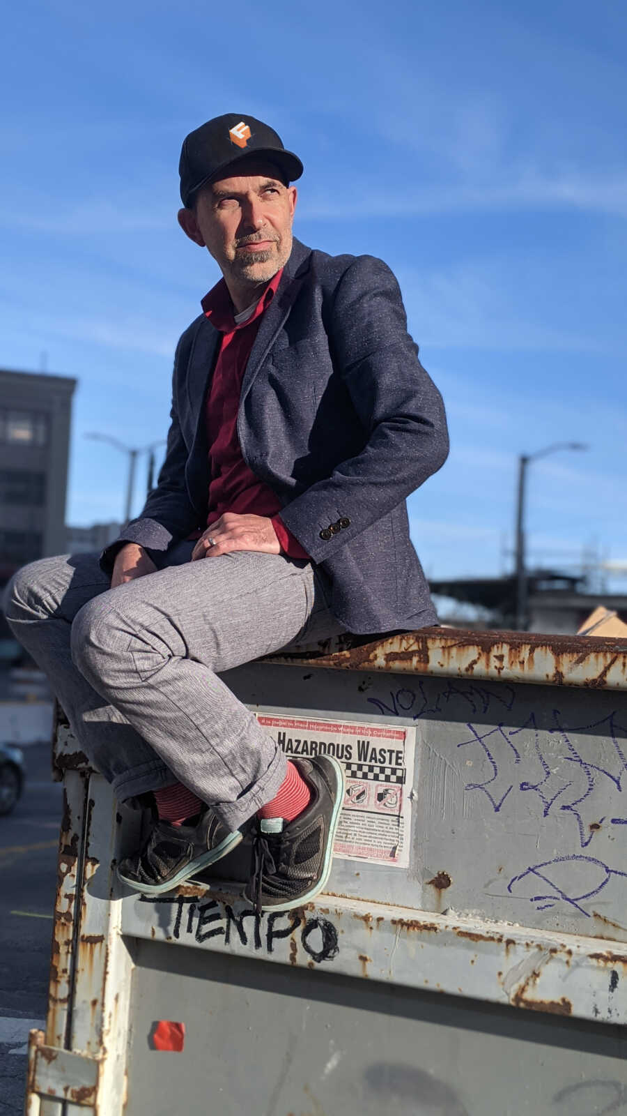 Sasha, founder and CEO of Formr, sits atop a dumpster.
