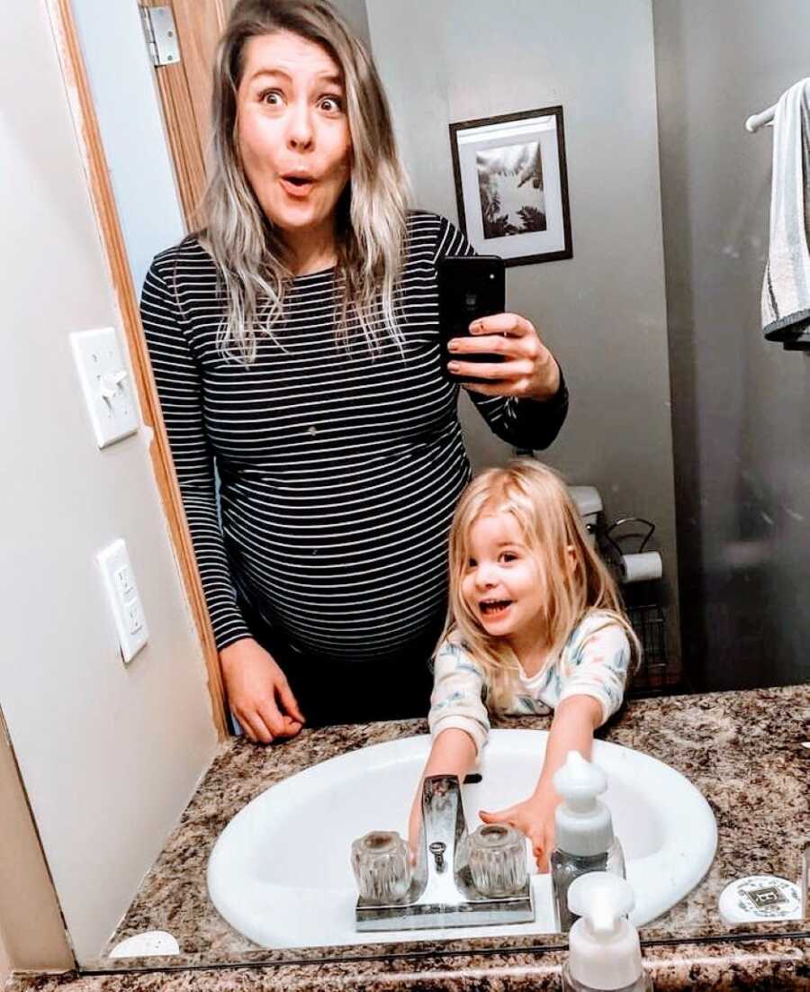 Pregnant mom and first daughter take silly photos in the mirror