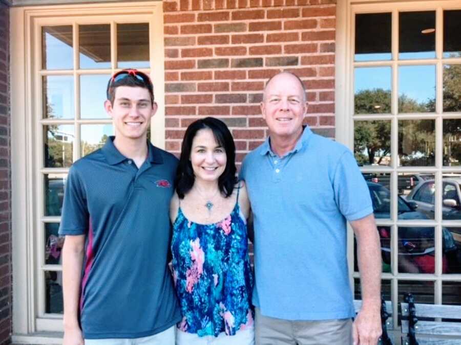 Mom and dad take photo with their son while dressed for church