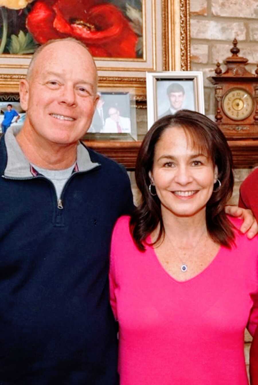 Husband and wife smile during a family photo