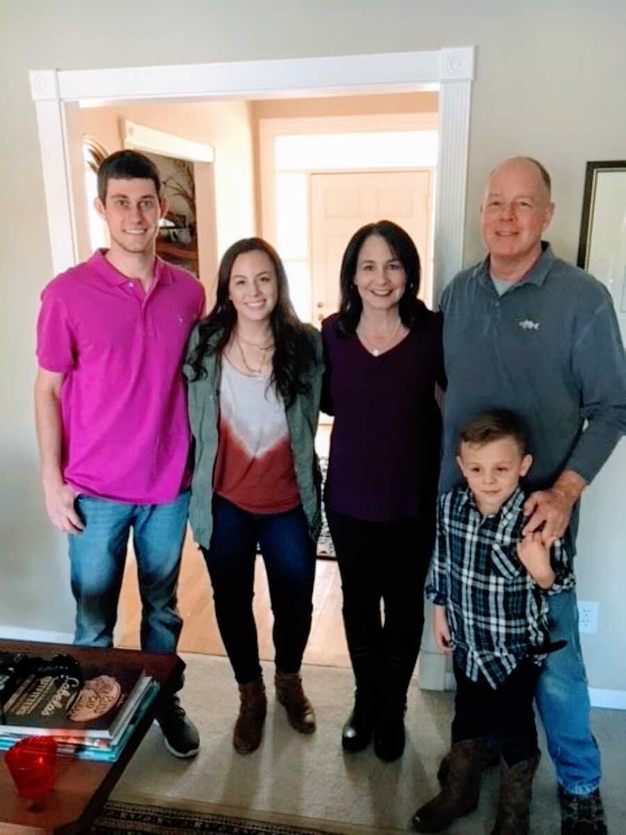 Family take Thanksgiving photo together in their living room