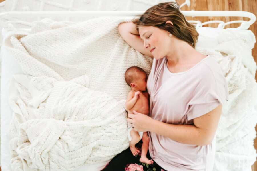 mom laying on the bed breastfeeding her child