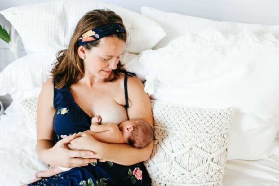 mom with her baby on her chest and breastfeeding the child