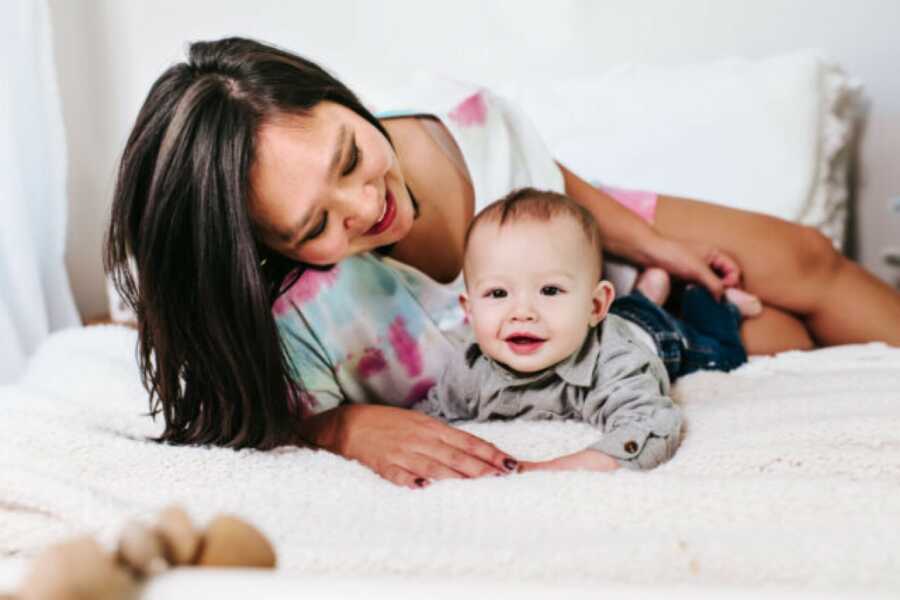 mom with her child on the bed smiling at him