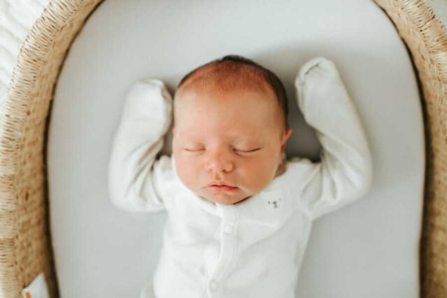 new born baby sleeping in their bassinet 