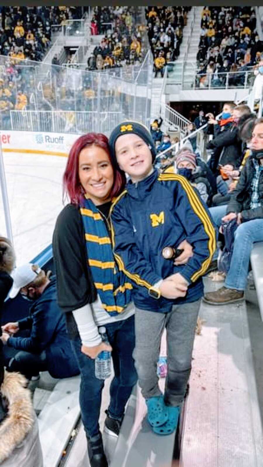 Mom and son smile big at hockey game