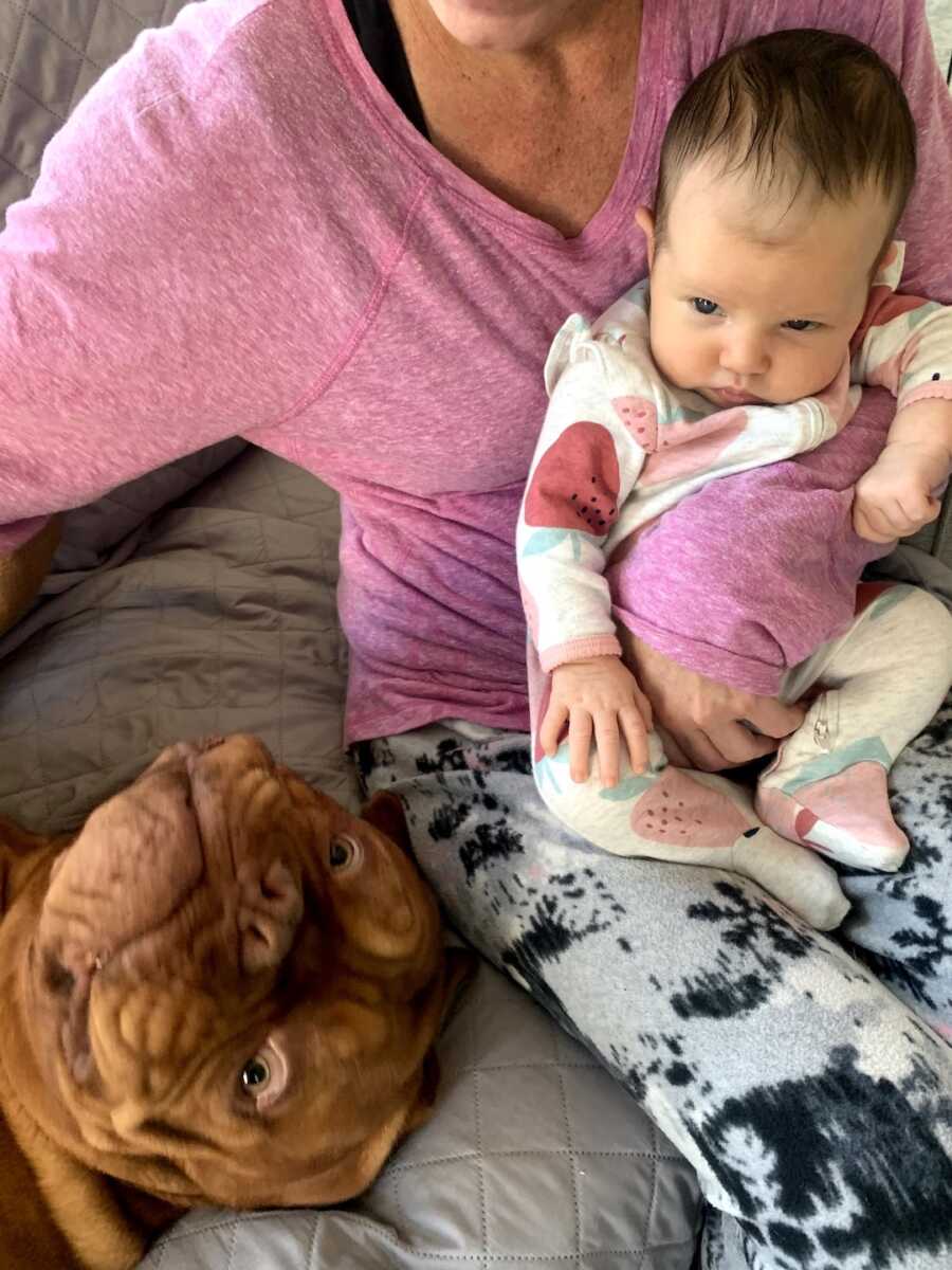 mom holding dog and baby