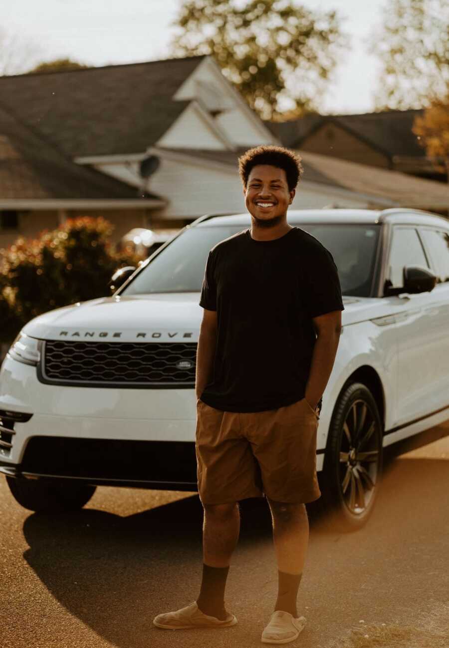 husband standing in front his new car