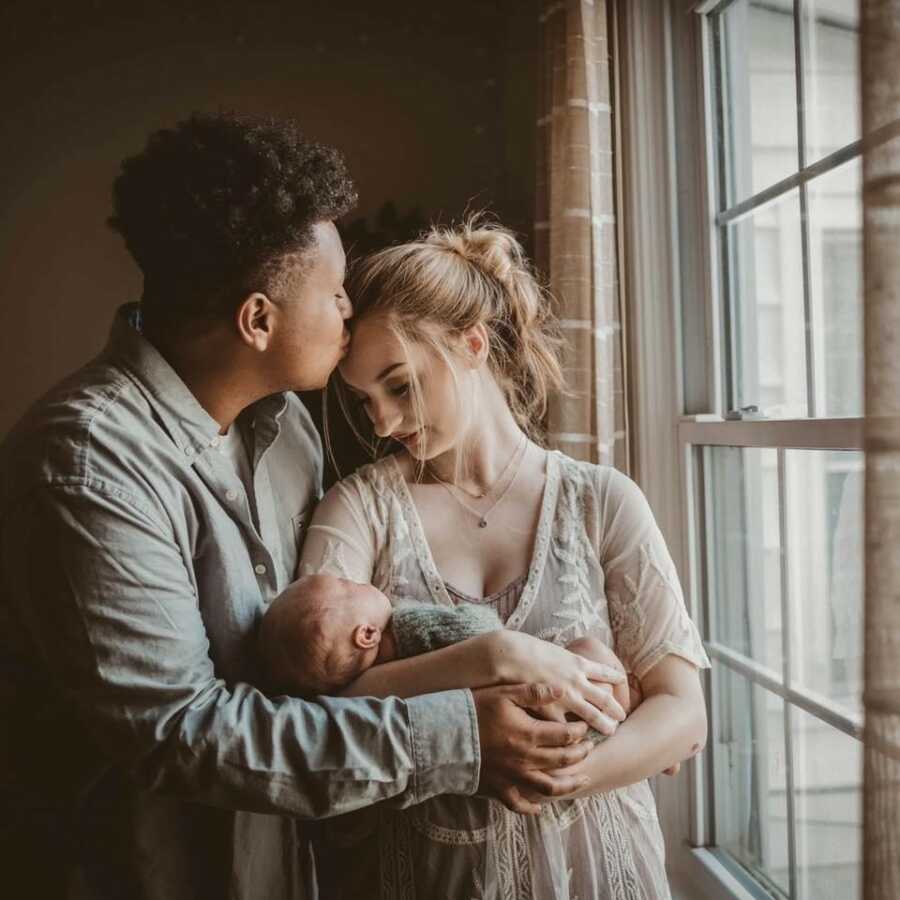 family posing in front of the window