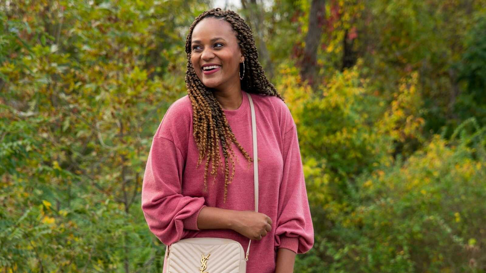 woman in a pink sweater dress looking beautiful against a green background