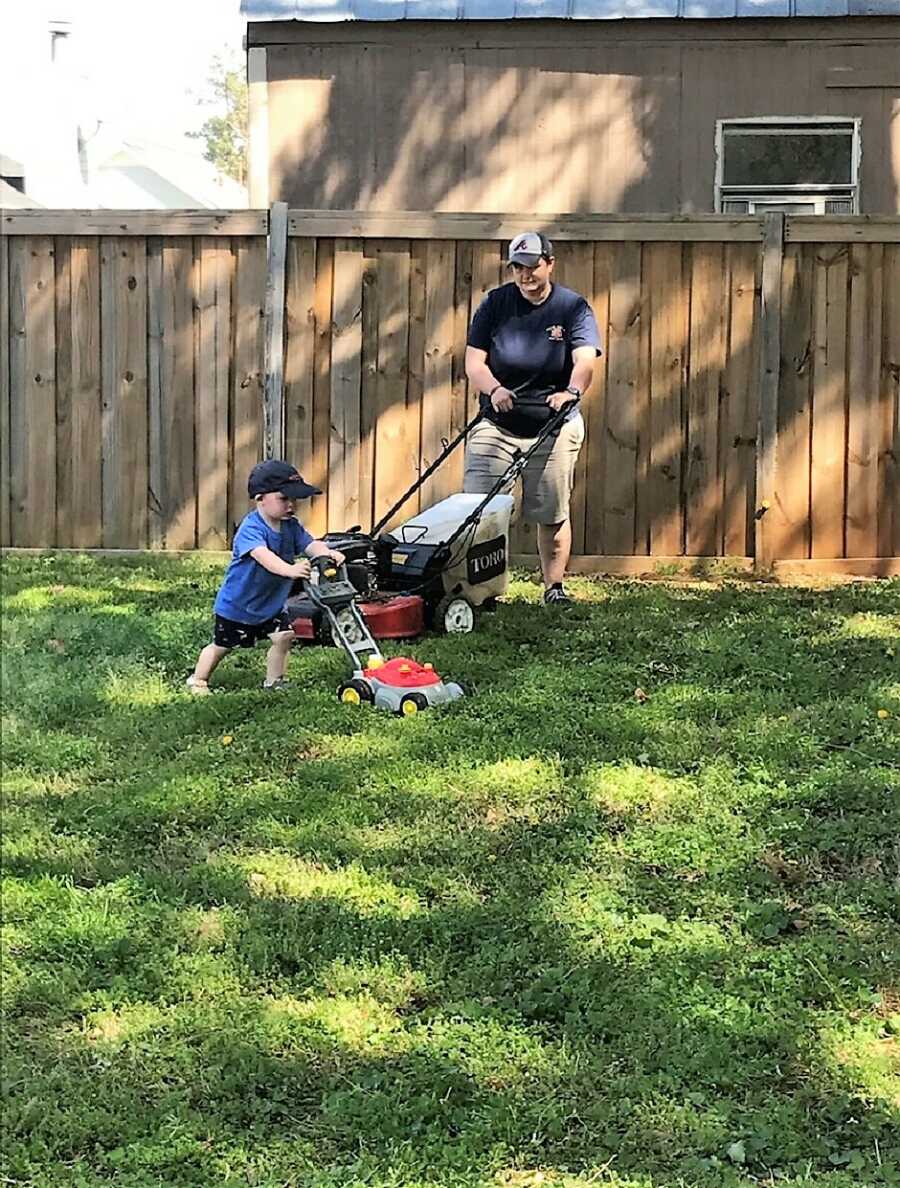 autistic boy imitating mother mowing the lawn with a lawn mower toy 