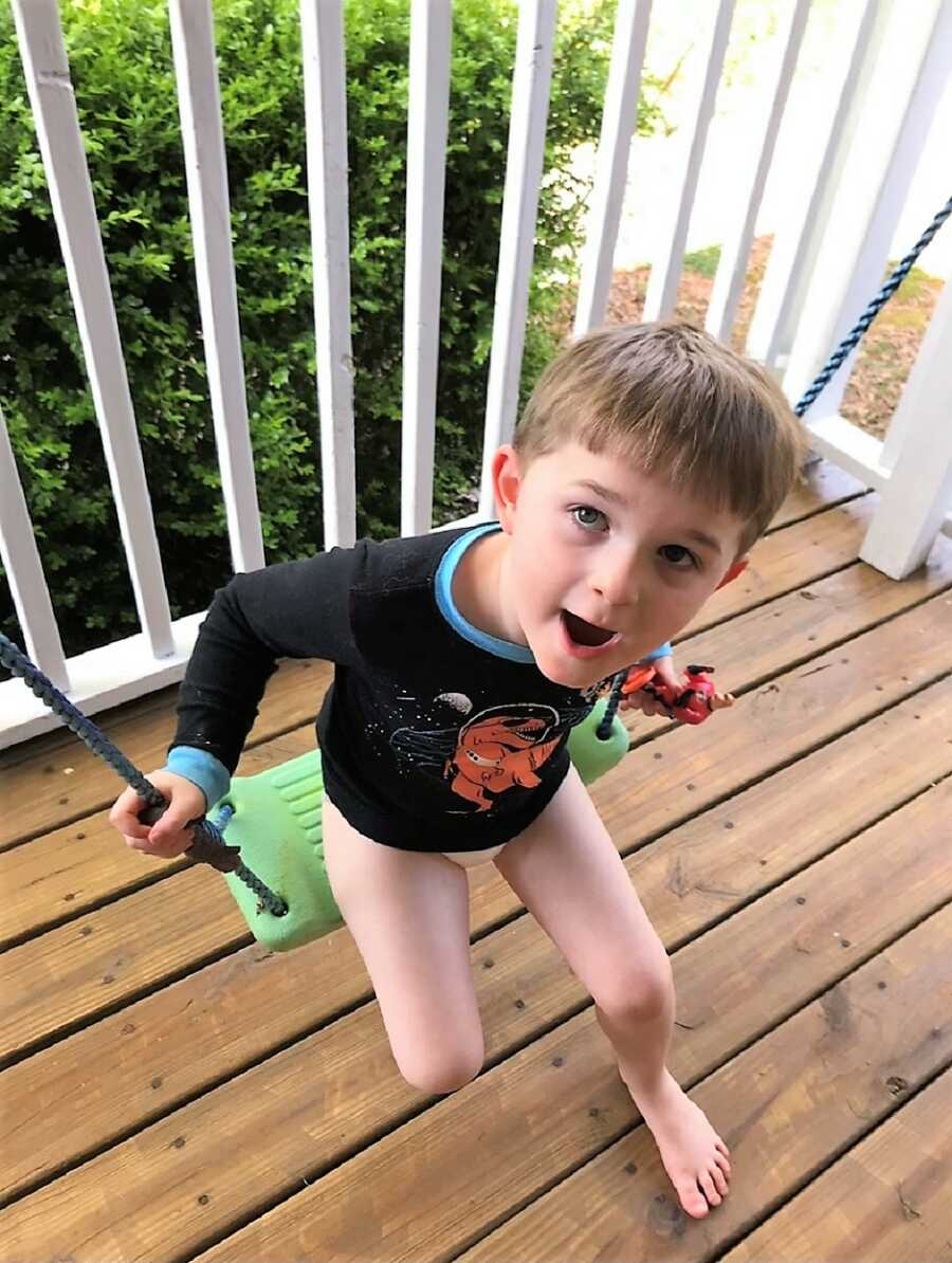 autistic boy playing barefoot in the porch swing for kids 