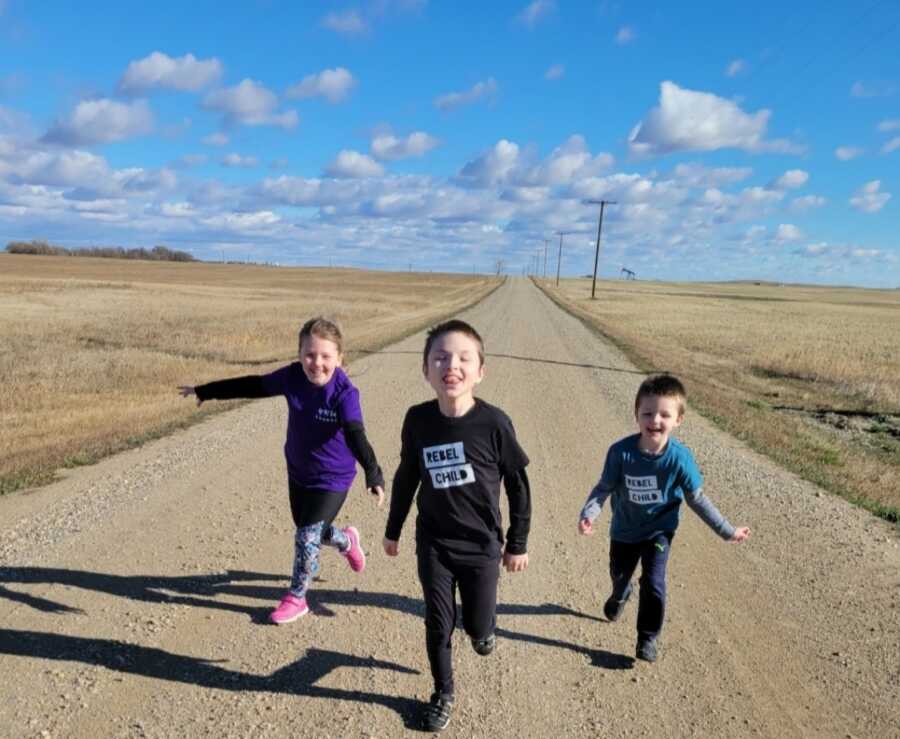 three kids running towards mom