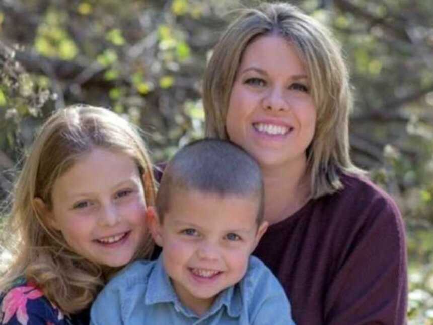 Single mom battling stage 4 cancer smiles with her two kids for a family photo