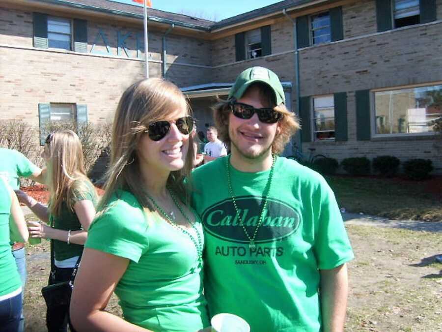 college couple at a St. Patrick's themed party wearing all green outfits and drinking alcohol 