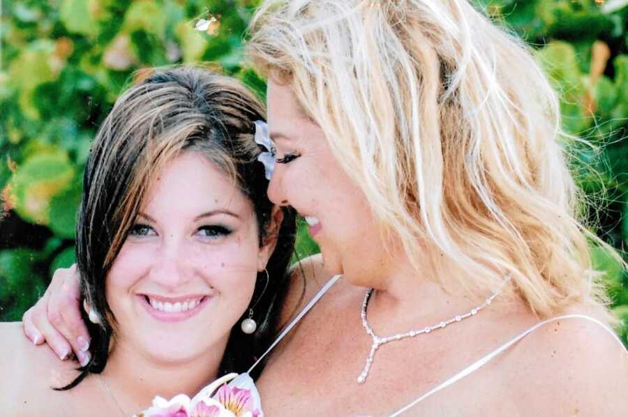 Birth mother looks down at her daughter in beautiful beach-themed photo