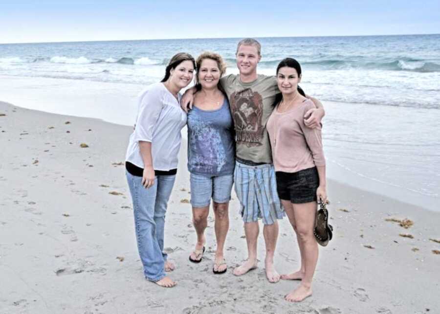 Biological family take a group photo on the beach