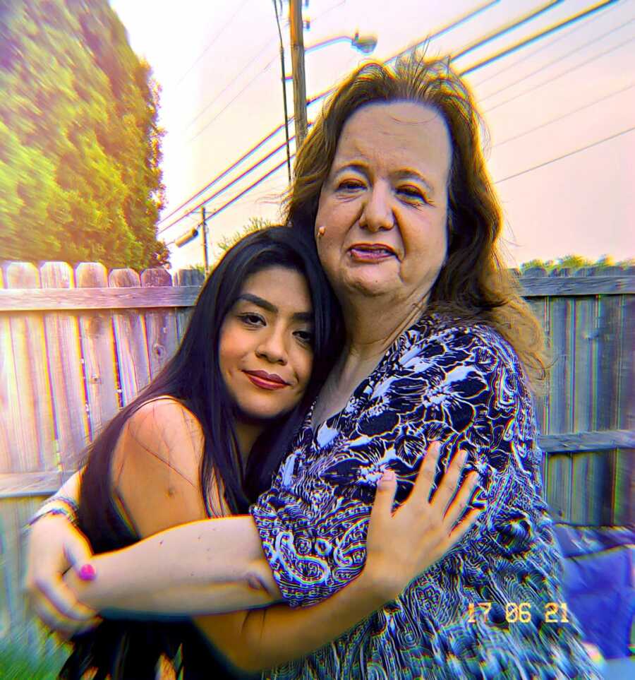 Woman and her former teen foster daughter embrace. 