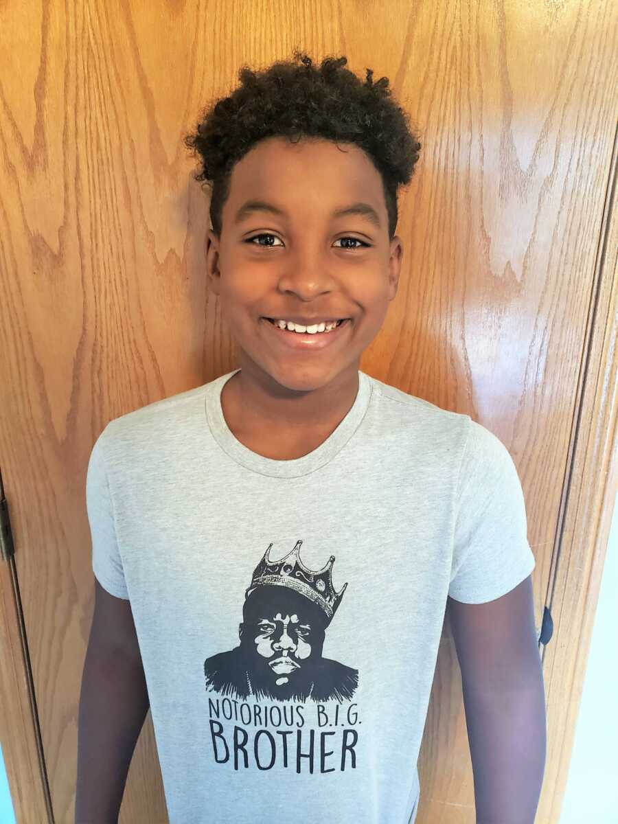 Big brother smiles big while wearing a 'Notorious B.I.G Brother' shirt