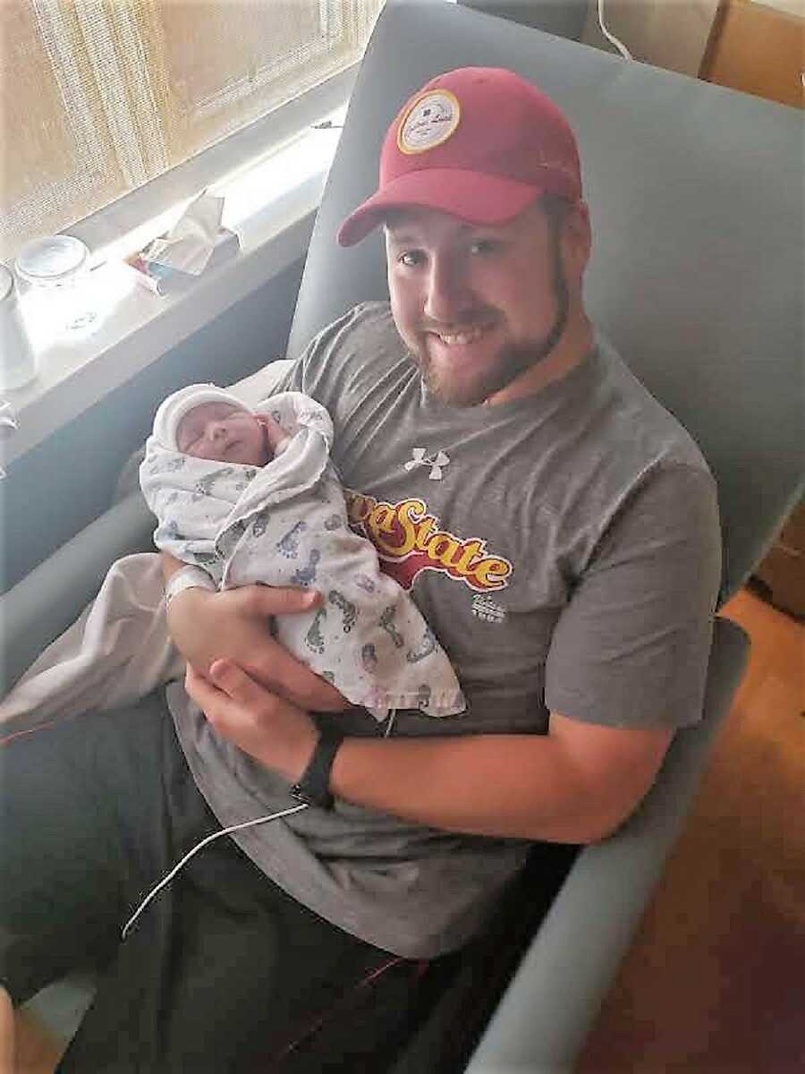Dad holds his newborn son in the hospital