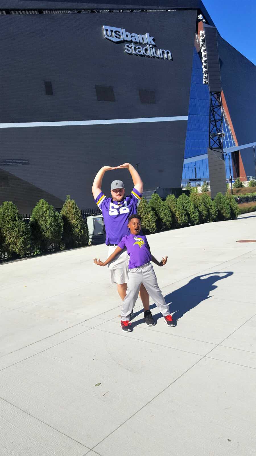 Mom takes a silly photo of her son and boyfriend in matching collegiate gear