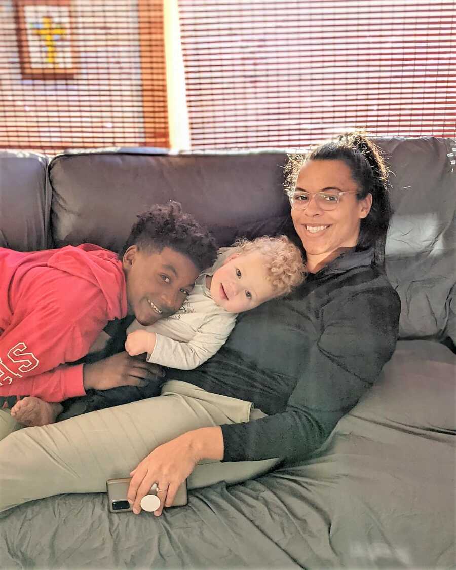 Mom cuddles with her two sons on the couch