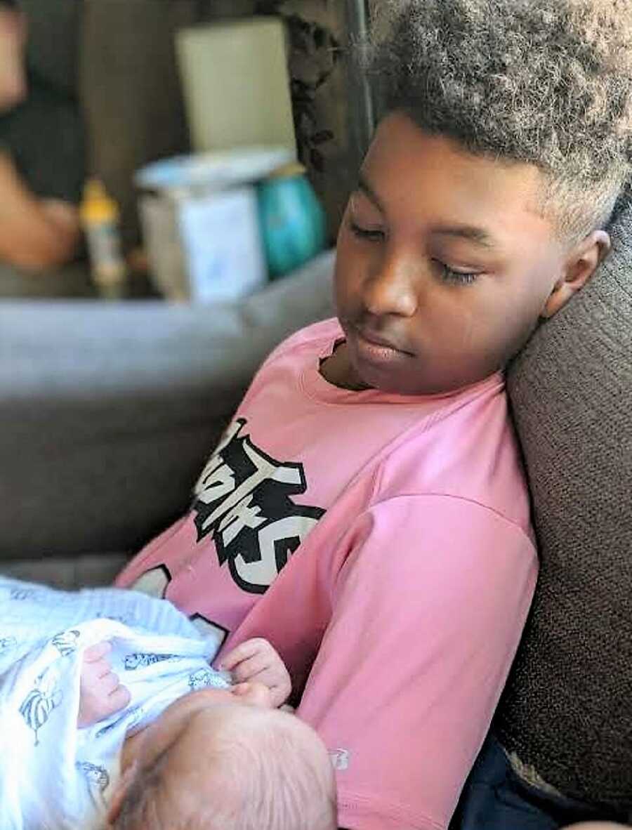 Big brother holds his newborn brother for the first time