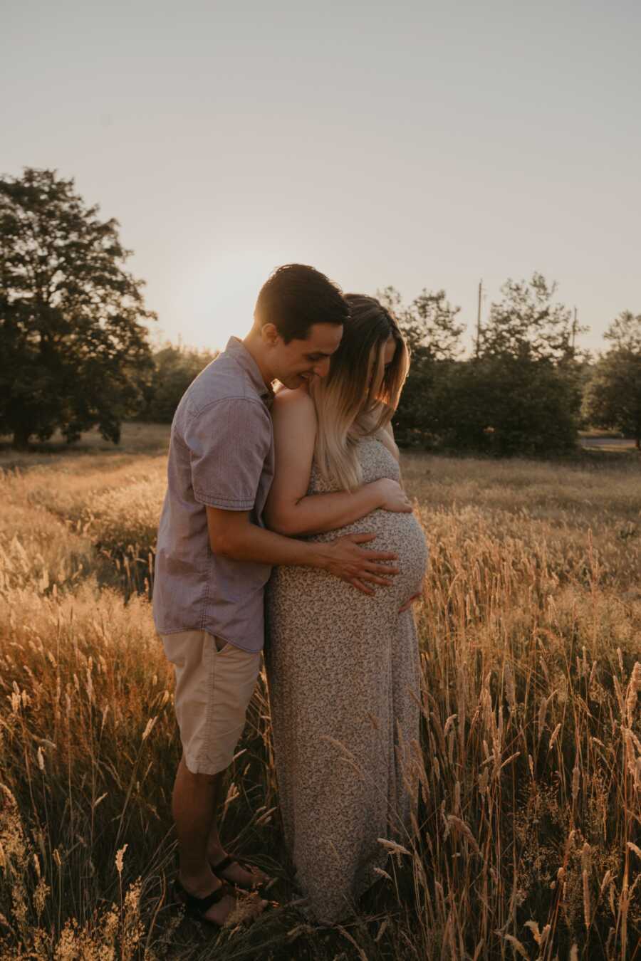 mom and dad holding the baby bump of pregnant wife