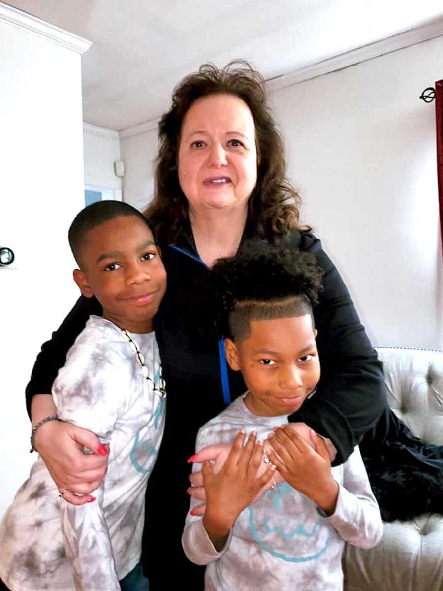 Adoptive mother embracing her two grandchildren.