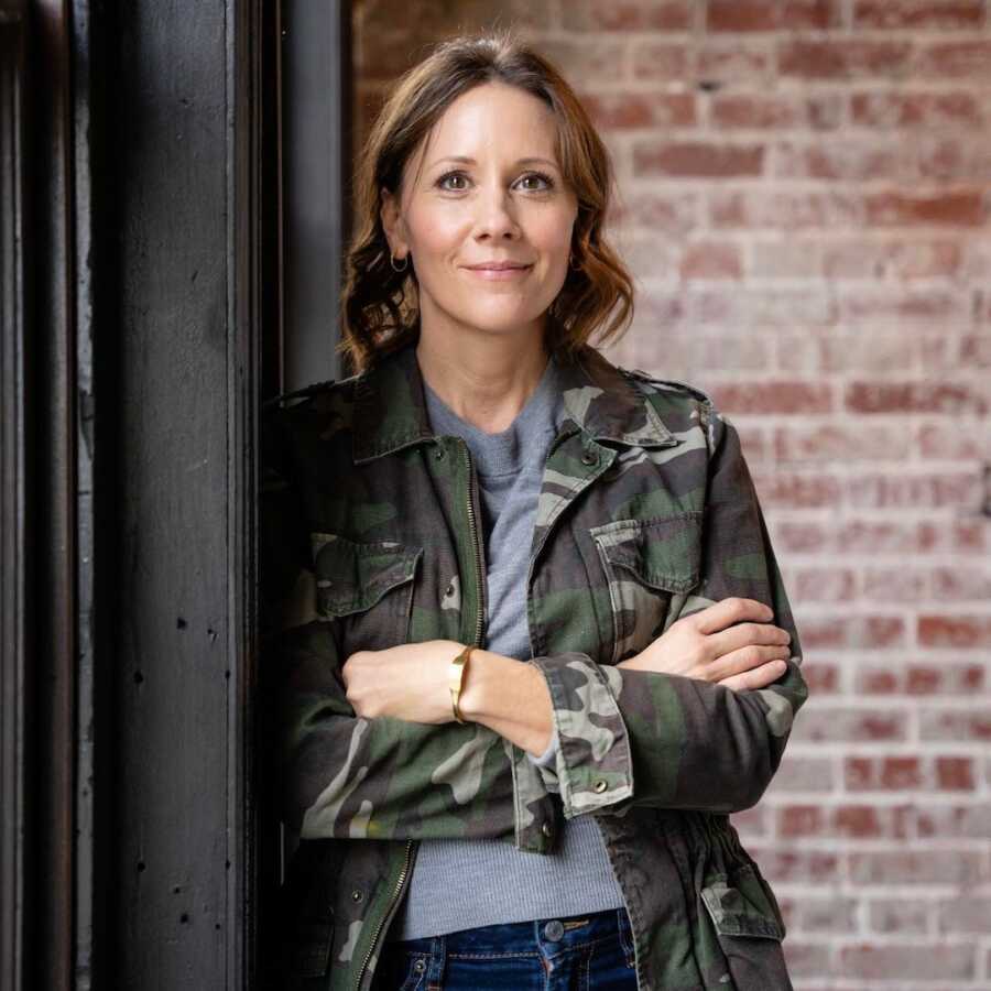 woman standing with her arms crossed in a camo jacket