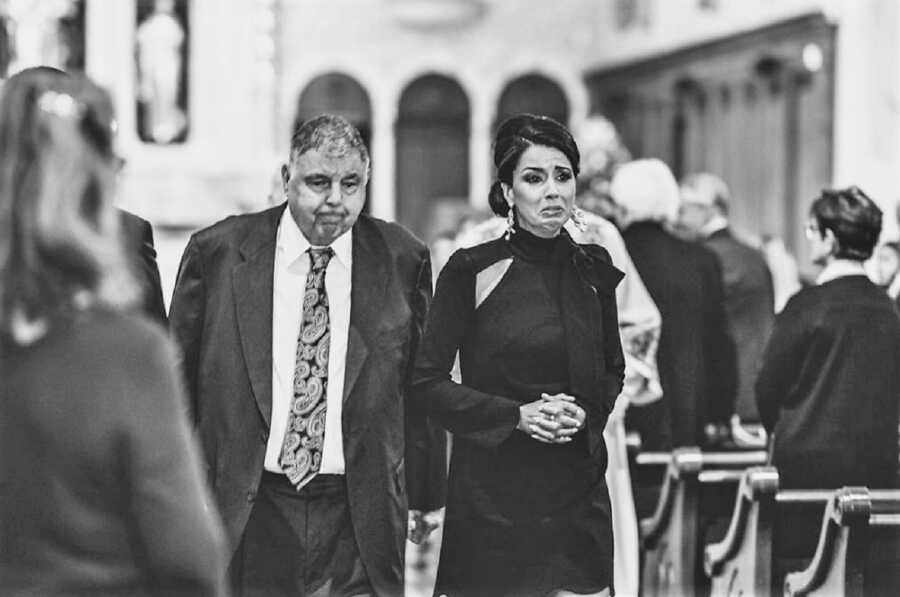 widow crying during husband's funeral at catholic church after tragic car accident 