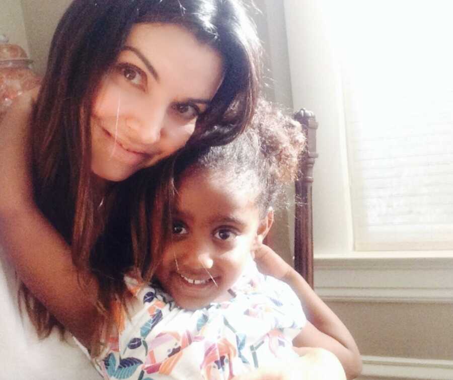 Empowerment coach for adult adoptees hugging her interracial adopted daughter