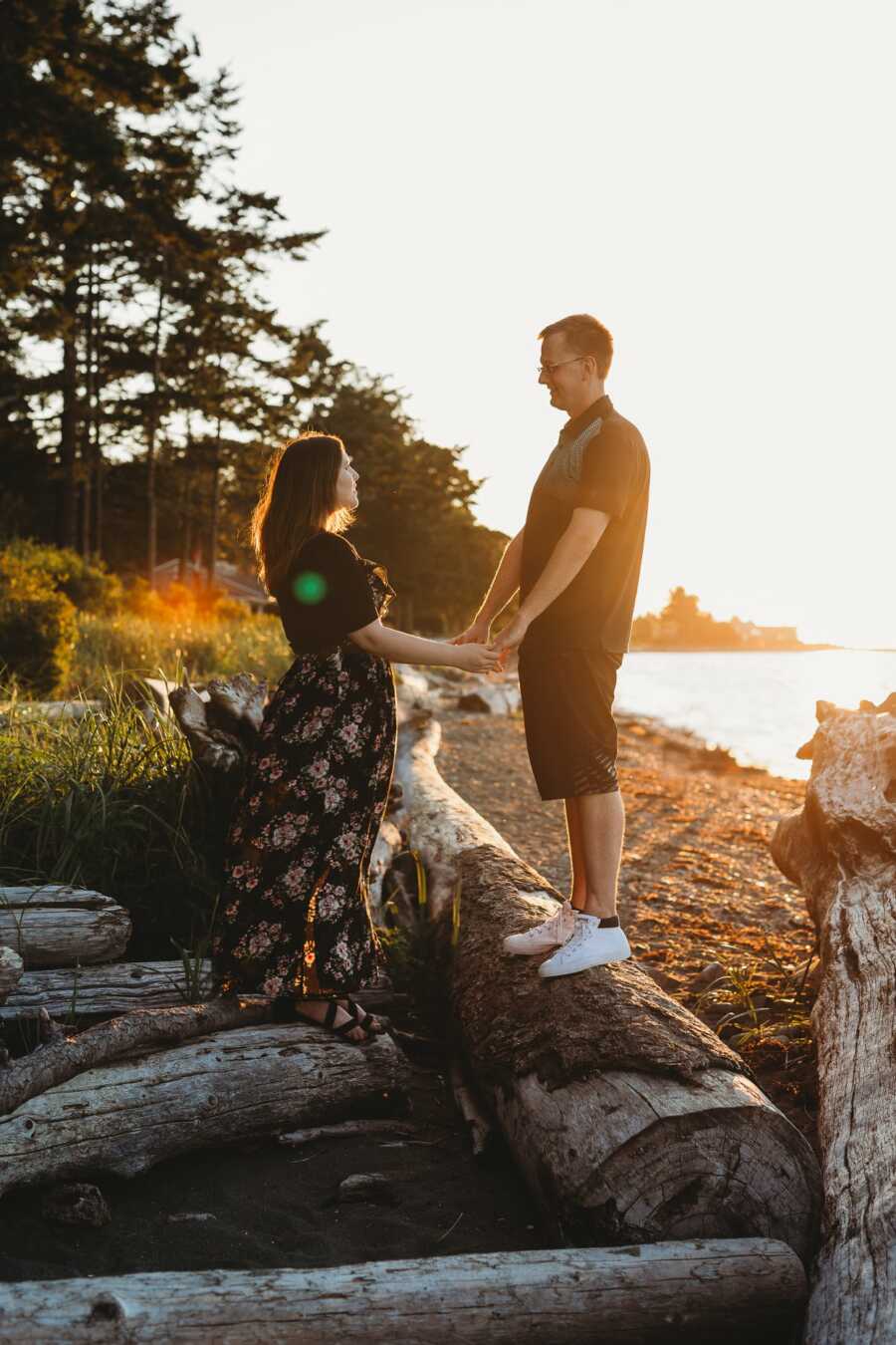 Couple share intimate moment together while on the beach during sunset