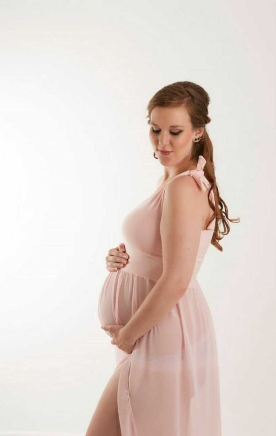 Woman pregnant with her first child looks stunning in maternity photoshoot in blush pink dress