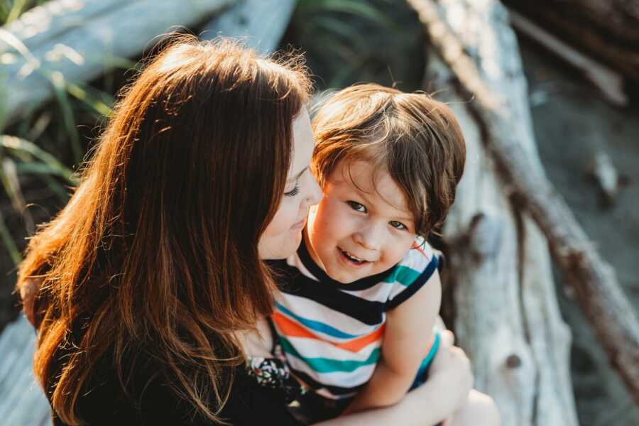 Mom shares sweet moment with son while watching the sunset at the beach